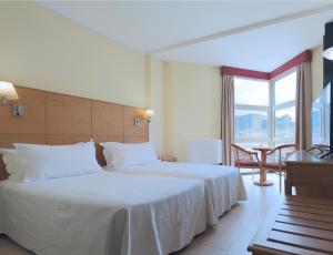 a hotel room with a bed and a large window at Dom Pedro Madeira in Machico
