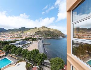 a view of the beach from a building window at Dom Pedro Madeira in Machico