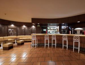 a bar in a restaurant with stools at Dom Pedro Madeira in Machico