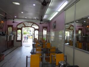 a restaurant with yellow tables and chairs in a building at Hotel Sri Sabthagiri in Puducherry