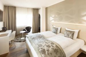 En eller flere senge i et værelse på Hotel Uzwil