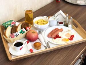 モスクワにあるセブン ヒルズ Brestskaya ホテルのテーブルの上に朝食用の食品とドリンクを用意したトレイ