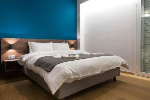 um quarto com uma cama grande e uma parede azul em TONI'S Cute Home for Couples, Archeological Museum em Atenas