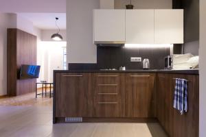 a kitchen with wooden cabinets and a stove top oven at TONI'S 2BD Modern flat in Koukaki near Acropoli in Athens