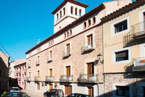 a large brick building with a clock tower on top at Santa Ana B&B in Darnius