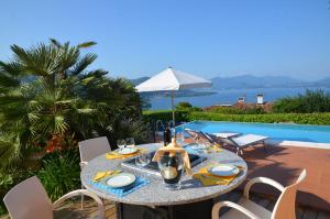 a table and chairs with a table and a pool at Villa Eva in Meina