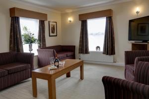 a living room with couches and a table and a tv at Burn Hall Hotel in Huby