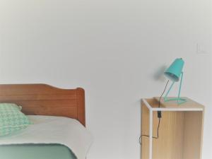 a bed with a blue lamp on a night stand at Casa de ls Cristales in Bemposta +34 photos