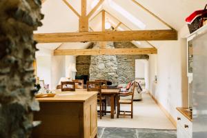 a kitchen and dining room with wooden beams at Glyn Mawr Barn in Bala