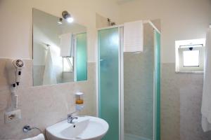 La salle de bains est pourvue d'un lavabo et d'une douche en verre. dans l'établissement B&B SELENE, à Castelnuovo Cilento