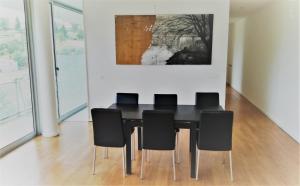 a dining room with a black table and black chairs at Casa de ls Cristales in Bemposta