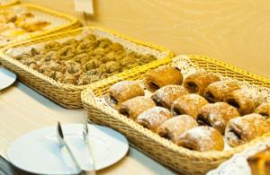 two baskets of pastries on a table with white plates at Luze Castellana in Madrid