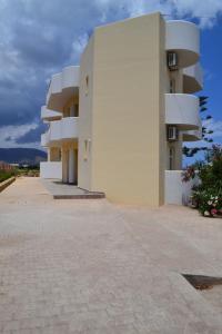 a white building with balconies on the side of it at Asteri apartments in Malia