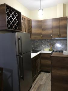 a kitchen with a refrigerator and wooden cabinets at Hill House in Kazbegi +42 photos