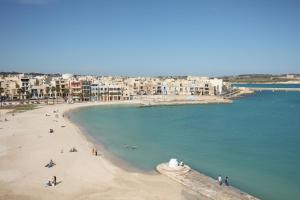 a view of a beach with buildings in the background at Water's Edge Hotel in Birżebbuġa