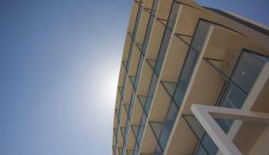 a facade of a building with glass at Water's Edge Hotel in Birżebbuġa