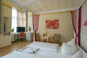 a bedroom with a bed and a desk and a television at Hotel Knöpel in Wismar