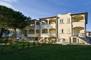 a large white building with a lawn in front of it at Villetta Tina in Vada