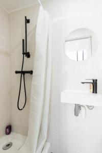 a white bathroom with a shower curtain and a sink at Malonat Duplex - Old Town in Nice