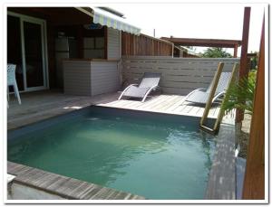 - une piscine avec 2 chaises et une terrasse dans l'établissement Quenetier, à Saint-François