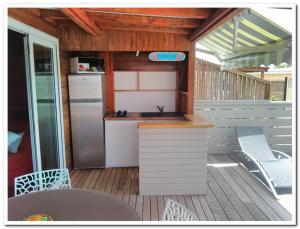 a kitchen with a sink and a refrigerator on a deck at Quenetier in Saint-François