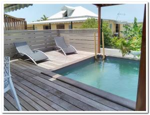 une terrasse avec deux chaises et une piscine dans l'établissement Quenetier, à Saint-François