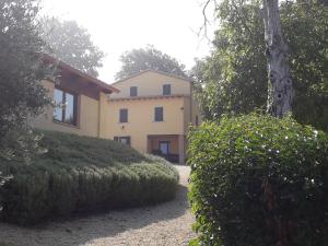 una gran casa amarilla con arbustos delante de ella en Agriturismo Il Truffarello TODI, en Todi