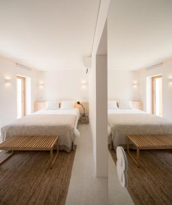 リスボンにあるCozy Lisbon Graçaの白い壁と窓が備わる客室で、ベッド2台が備わります。