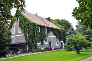 a house with ivy growing on the side of it at Pałac Heymanna - Oficyna in Ścibórz