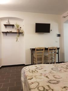 a room with a bed and a table and a tv at La Stanzetta Dei Rosa in Portovenere