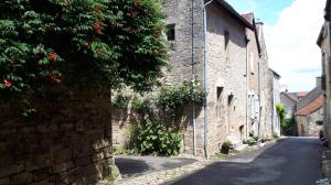 an alley in an old stone building with a tree at La Maison de Pierre in Flavigny-sur-Ozerain