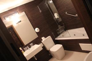昆卡的住宿－昆卡酒店，浴室配有卫生间、盥洗盆和浴缸。