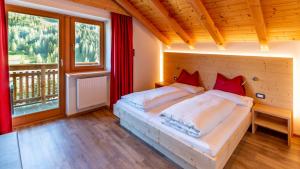 a bedroom with a bed and a large window at Villa Hilde in San Cassiano