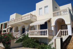 a white house with white balconies and flowers at Pantelis Studio in Paralia Agias Foteinis +31 photos