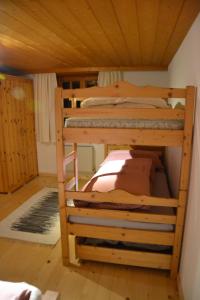 2 Etagenbetten in einem Zimmer mit Holzdecke in der Unterkunft Sunnaschi Appartements - Wohnungen oder gesamt als "Hütte" in Laterns