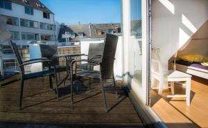 balcón con sillas, mesa y ventana en Altstadt Apartment Charly, en Düsseldorf
