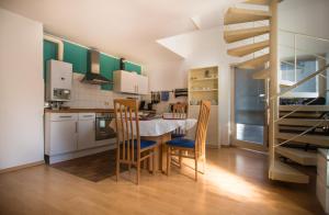 a kitchen with a table and chairs and a staircase at Altstadt Apartment Charly in Düsseldorf