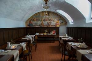 a dining room with tables and a painting on the wall at Convento San Bernardino in Montefranco