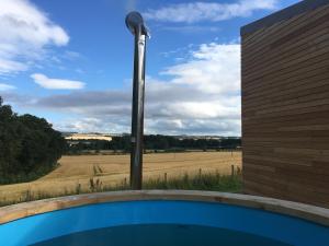 a pool with a view of a field from a building at Orchard Hideaway in Kelso