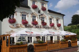 a building with umbrellas in front of it at Landgasthof Zum Schützenhaus Sosa in Eibenstock