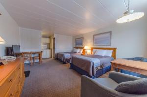 Habitación de hotel con 2 camas y escritorio en Lark Motel, en Stone Harbor