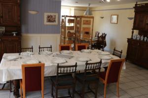une table à manger avec des chaises et un tissu de table blanc dans l'établissement Chambres et table d’hôtes le Barret, à Beauzac