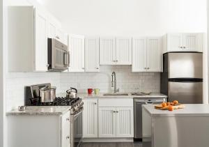 a kitchen with white appliances and white cabinets at The Provincetown Hotel at Gabriel's in Provincetown