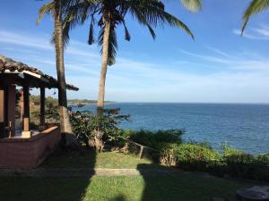 a view of the ocean from a house with palm trees at Hotel Punta Franca in Jobal
