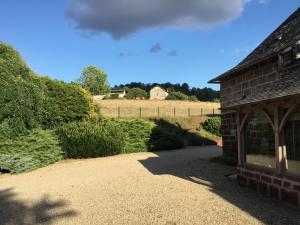 un edificio di mattoni con un percorso che conduce a un campo di Le clos de rose a Ussac