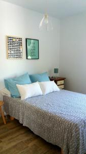 sypialnia z łóżkiem z niebiesko-białymi poduszkami w obiekcie Casa del Mar w mieście Puerto Real