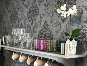 a shelf with glasses and vases on it at Punta Preko Apartments in Preko