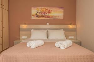 Dionos Villa في أسوس: غرفة نوم مع منشفتين على سرير