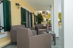 a patio with wicker chairs and tables on a building at Dionos Villa in Asos