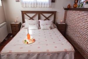 a bedroom with a bed with a plate of food on it at Casa Rural El Mendrugo in Tornadizos de Ávila
